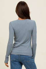 woman wearing a fitted long sleeve ribbed top in light blue, seen from the back with her hair down