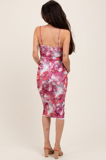woman wearing a pink and white floral print maternity dress with spaghetti straps and a fitted silhouette