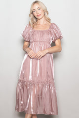 woman wearing a shiny blush pink puff sleeve midi dress with a square neckline and tiered skirt