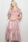 woman wearing a shiny blush pink puff sleeve midi dress with a square neckline and tiered skirt