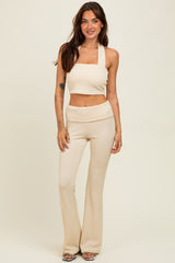 woman wearing a cream ribbed two-piece set with a square neck crop top and flared pants