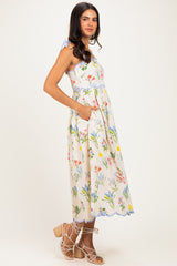 woman wearing a floral print midi dress with a halter neck and pockets, styled with strappy sandals