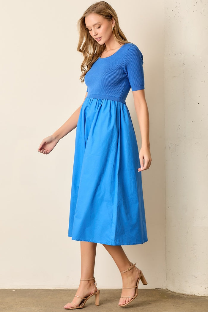 woman wearing a royal blue ribbed short sleeve dress with a fitted bodice and flowy skirt