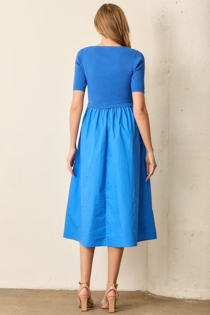 woman wearing a blue short sleeve knit and skirt midi dress, showing the back view