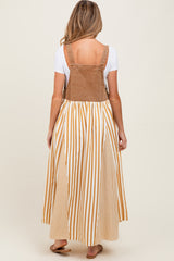 woman wearing a brown corduroy maternity maxi dress with white and mustard stripes and a fitted bodice