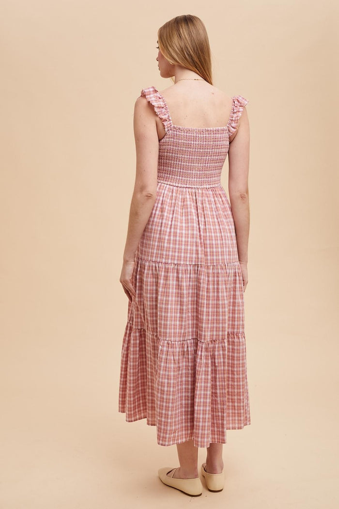 woman wearing a pink gingham tiered maxi dress with ruffled straps, seen from the back