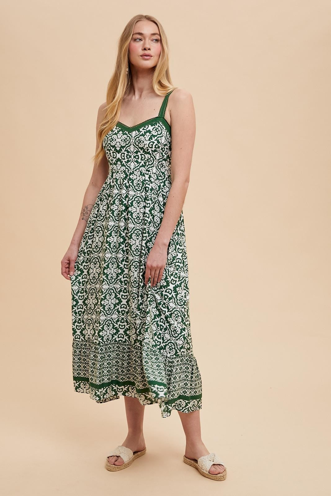 woman wearing a green patterned maxi dress with spaghetti straps and a flowing silhouette
