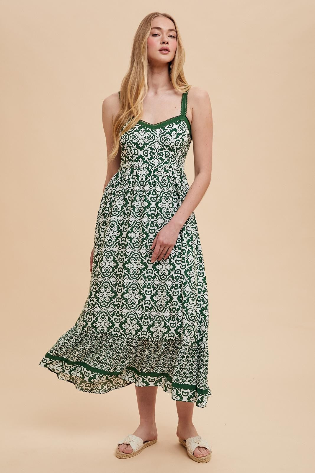 woman wearing a green and white patterned maxi dress with spaghetti straps and a flowy hemline