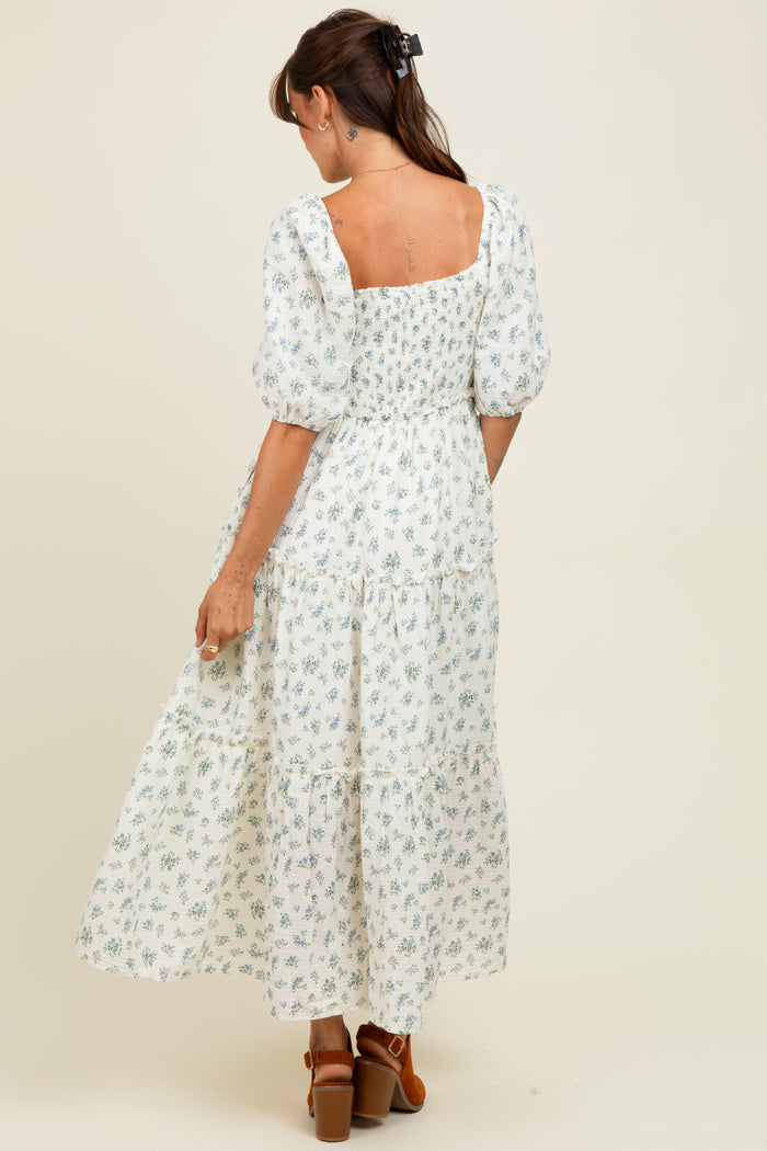 woman wearing a white floral maxi dress with puff sleeves and a smocked bodice, shown from the back
