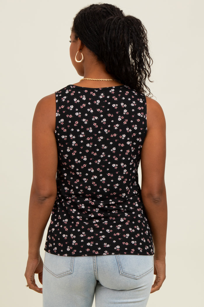 woman wearing a black sleeveless top with a floral print, viewed from the back, paired with light blue jeans