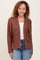 woman wearing a rust brown open front cardigan over a white top and blue jeans