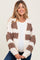 woman wearing a cream and brown patterned maternity cardigan, showcasing her baby bump