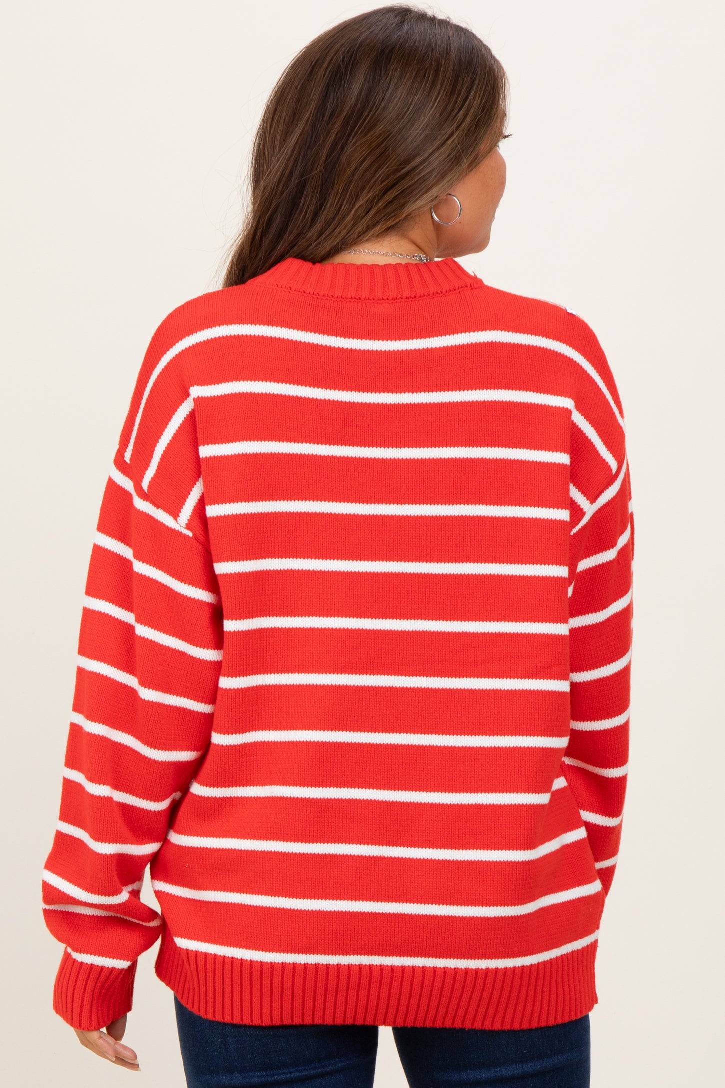 woman wearing a red and white striped maternity sweater, viewed from the back