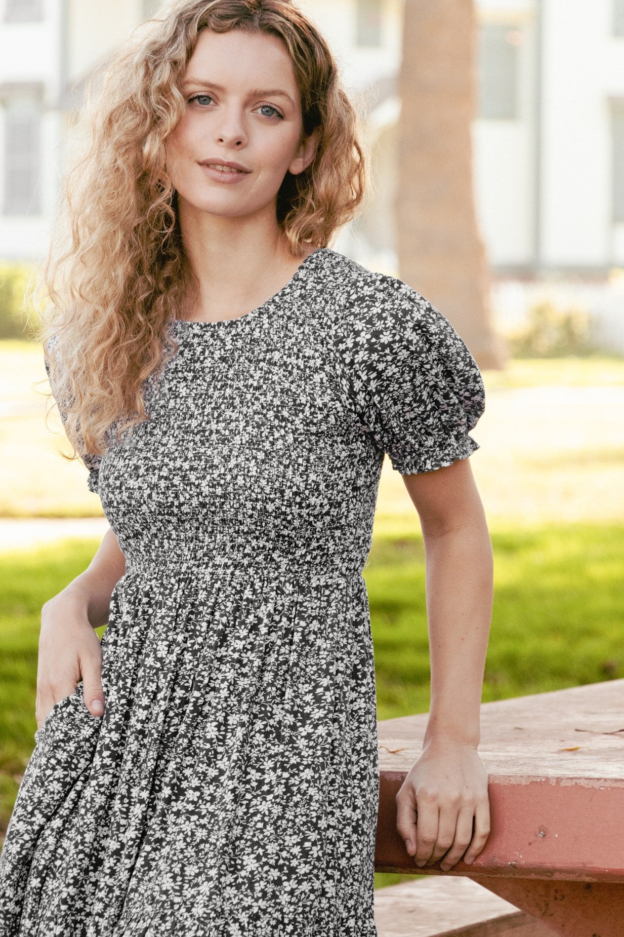 woman wearing a black and white floral print short sleeve dress with a fitted bodice and puff sleeves
