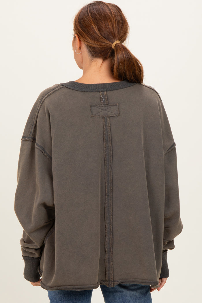 woman wearing an oversized charcoal gray fleece sweatshirt with a back seam detail