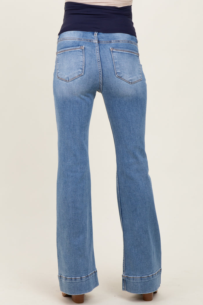 woman wearing light blue maternity flared jeans with a stretchy dark waistband, showcasing the back view