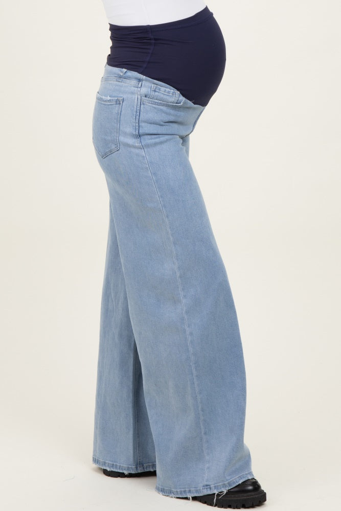 woman wearing light blue wide-leg maternity jeans with a navy belly panel and a visible baby bump