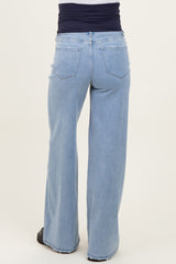 woman wearing light blue maternity jeans, viewed from the back, featuring a wide-leg style and an elastic waistband