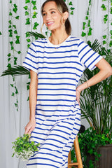 woman wearing a white and blue striped short sleeve dress while holding a small bouquet of flowers