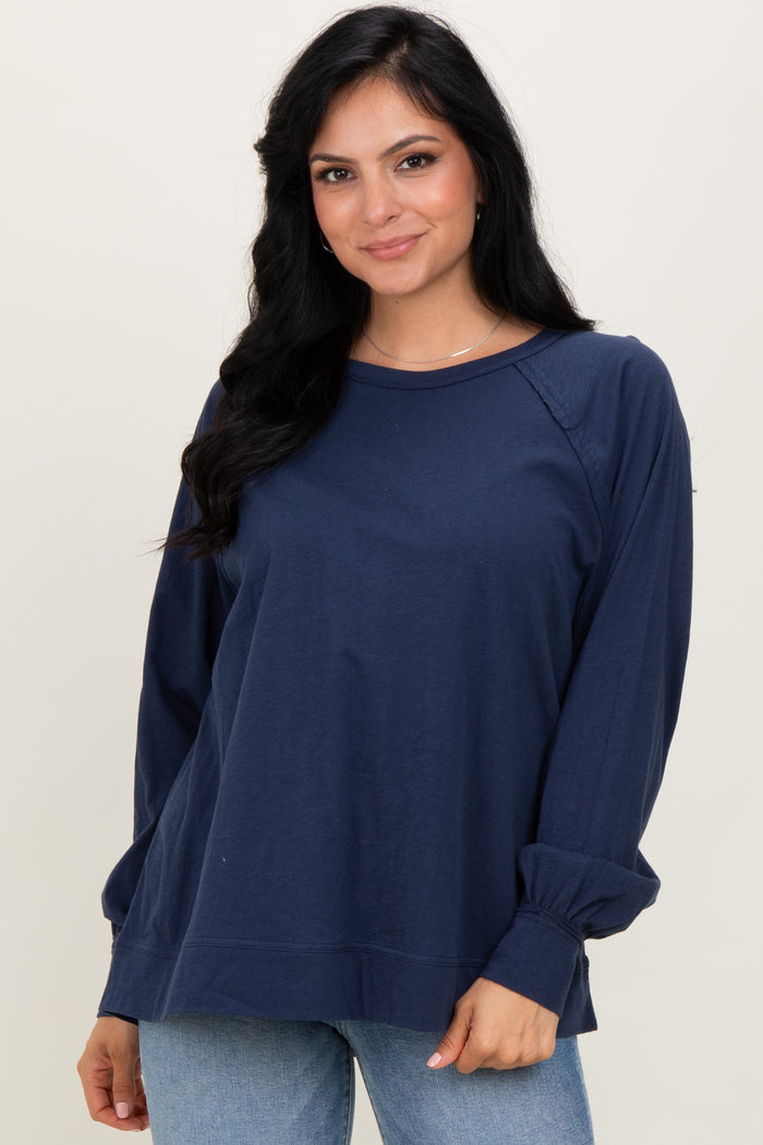 woman wearing a navy blue long sleeve top with a relaxed fit and drop shoulder detailing