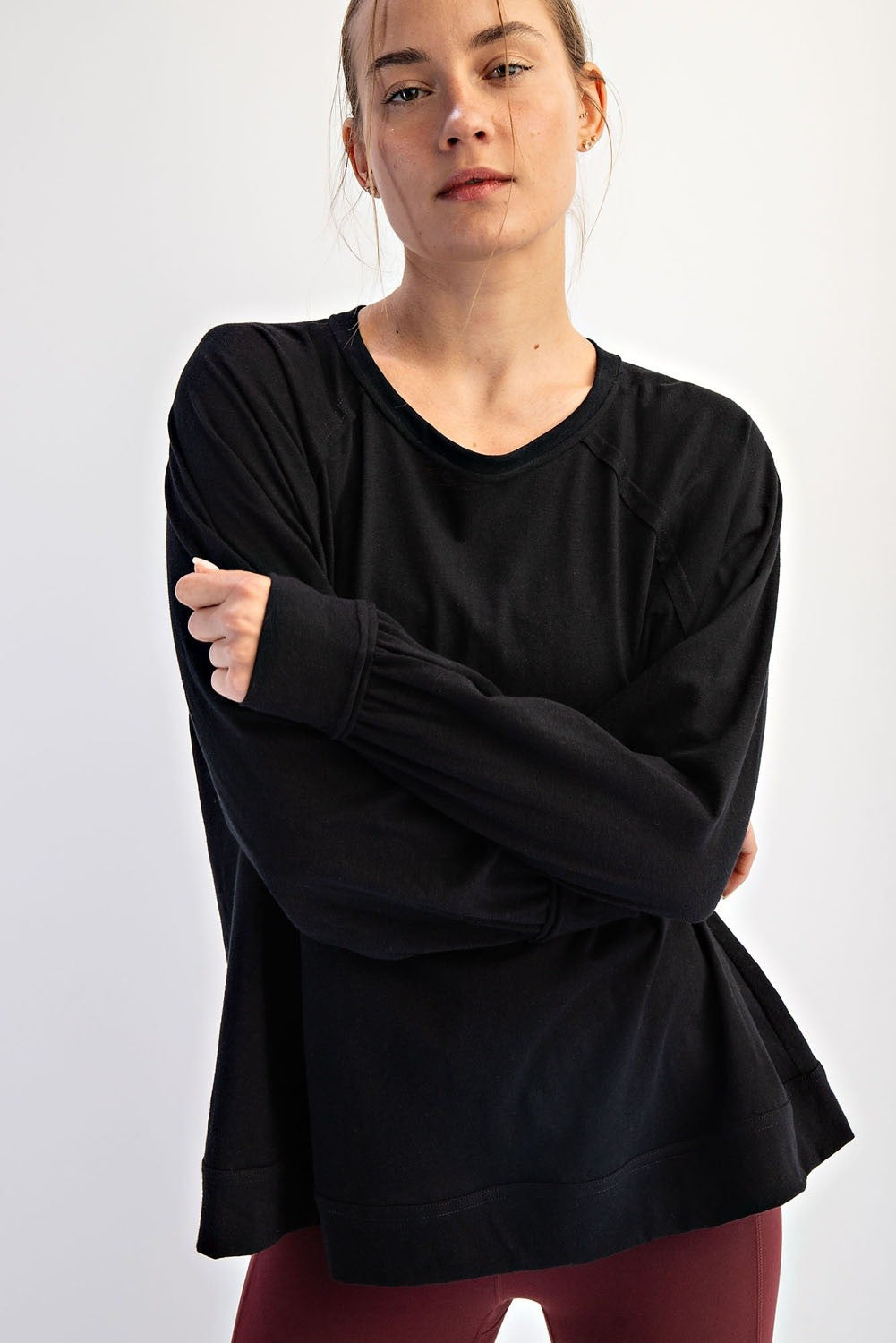 woman wearing a black long sleeve athletic top with a relaxed fit and raglan sleeves