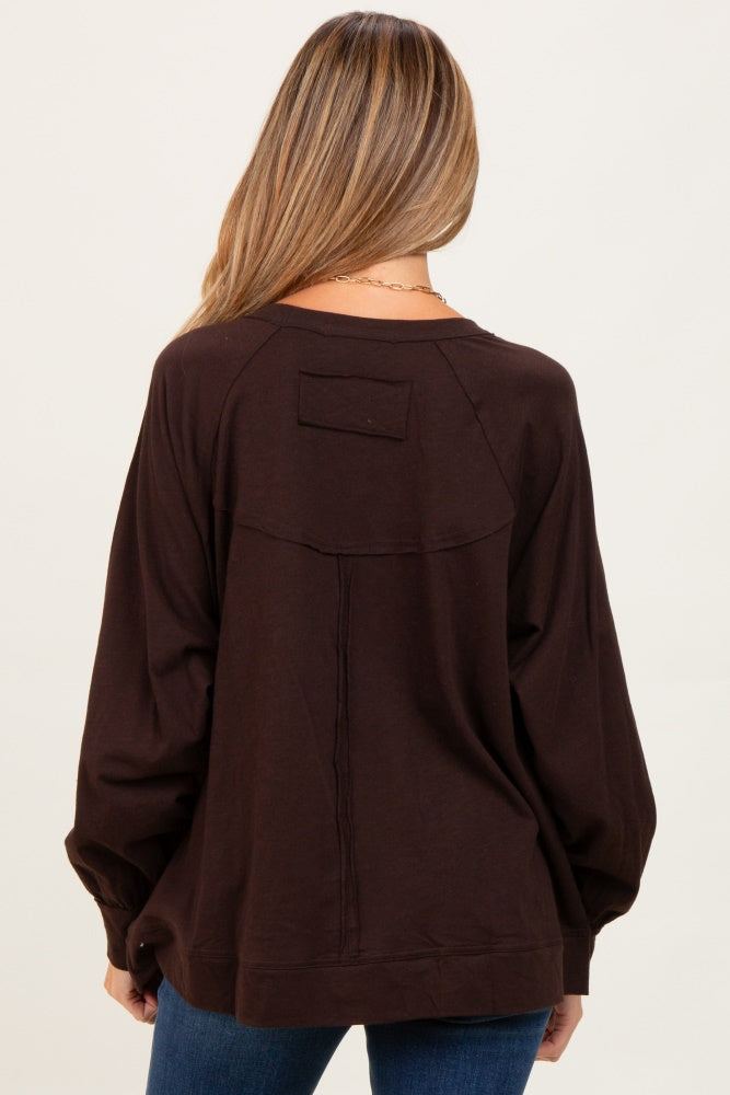 woman wearing a brown oversized maternity sweatshirt with a relaxed fit and puffed sleeves, seen from the back