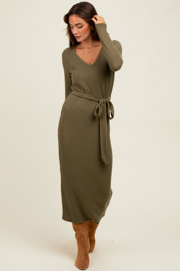 woman wearing an olive green ribbed long sleeve maxi dress with a tie belt and knee-high brown boots