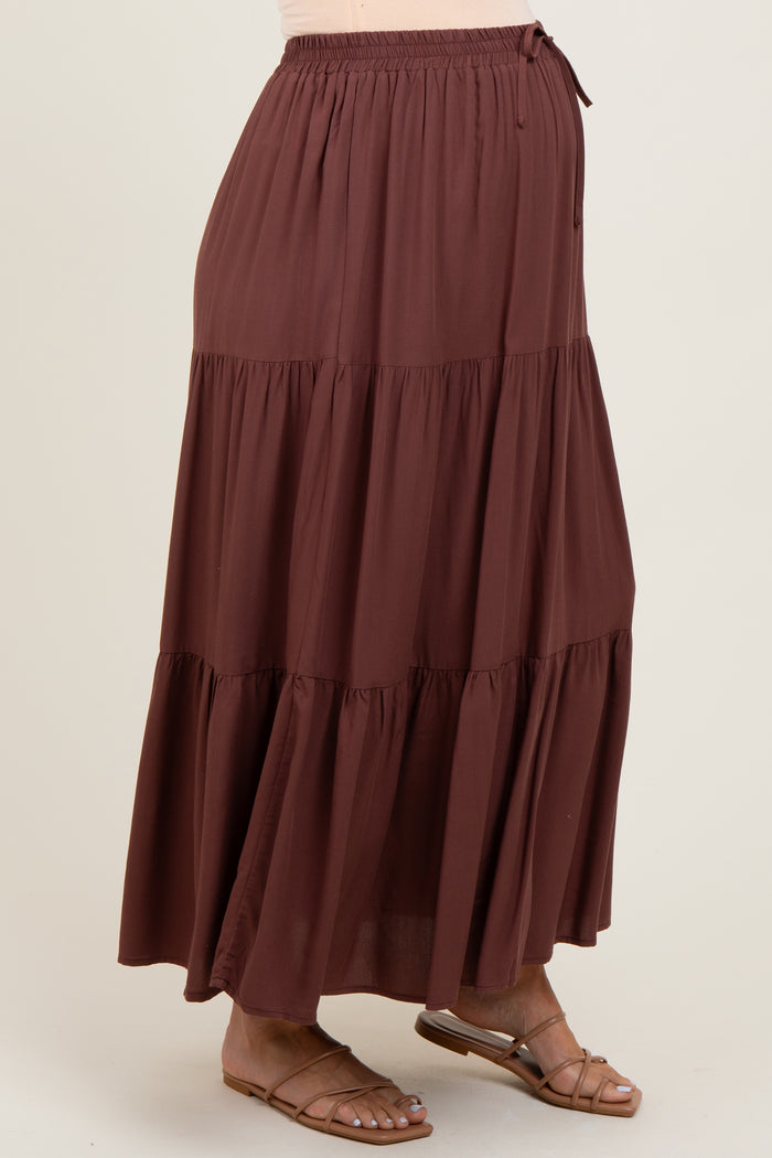 woman wearing a rust-colored tiered maternity skirt with an elastic waistband and tie detail