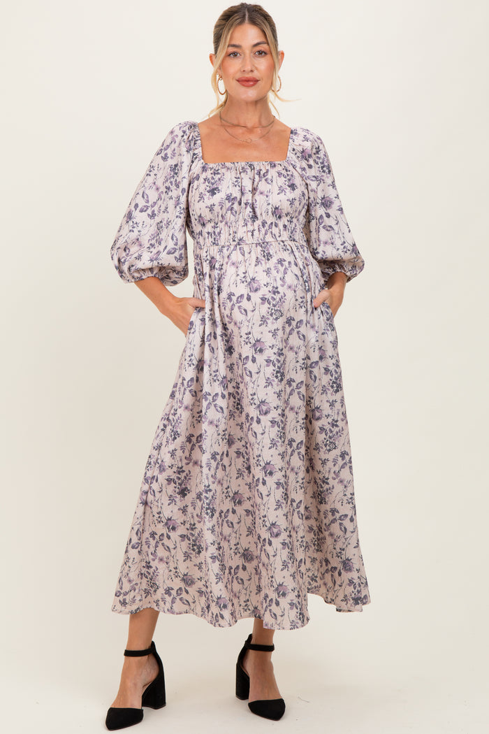 woman wearing a floral print maternity dress with puff sleeves and a square neckline, highlighting her baby bump