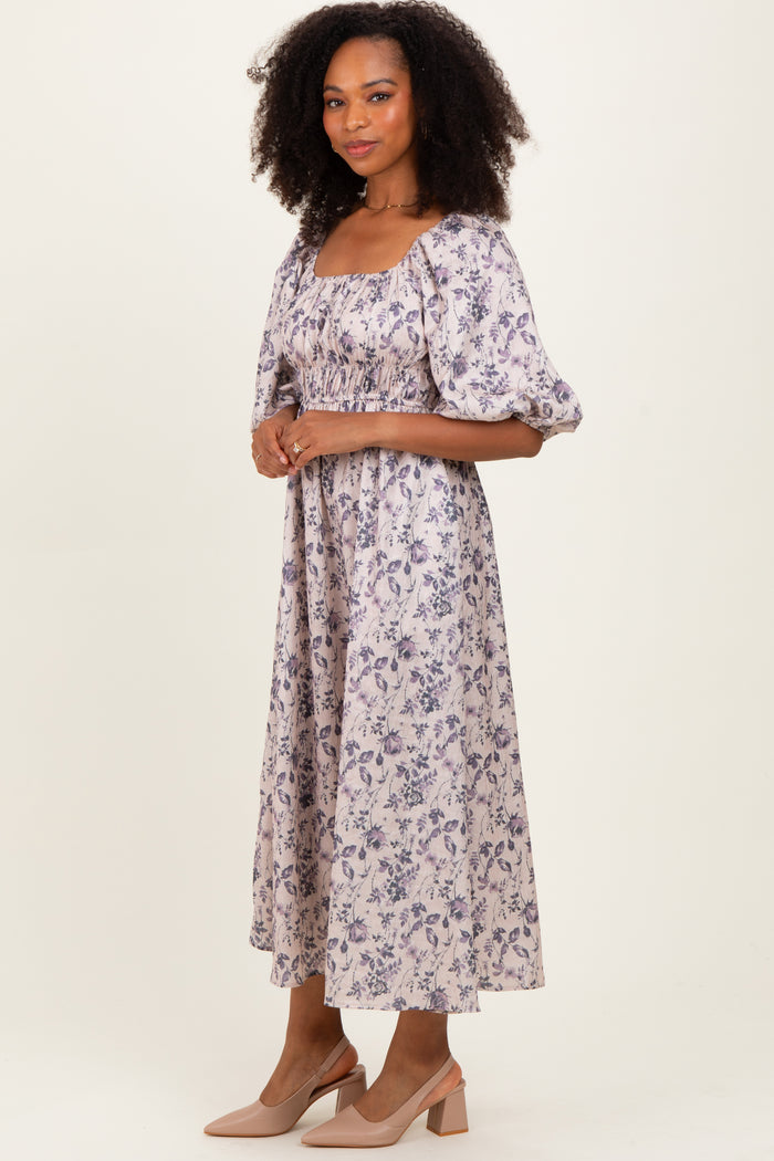 woman wearing a lavender floral midi dress with puff sleeves and a square neckline, standing in a relaxed pose