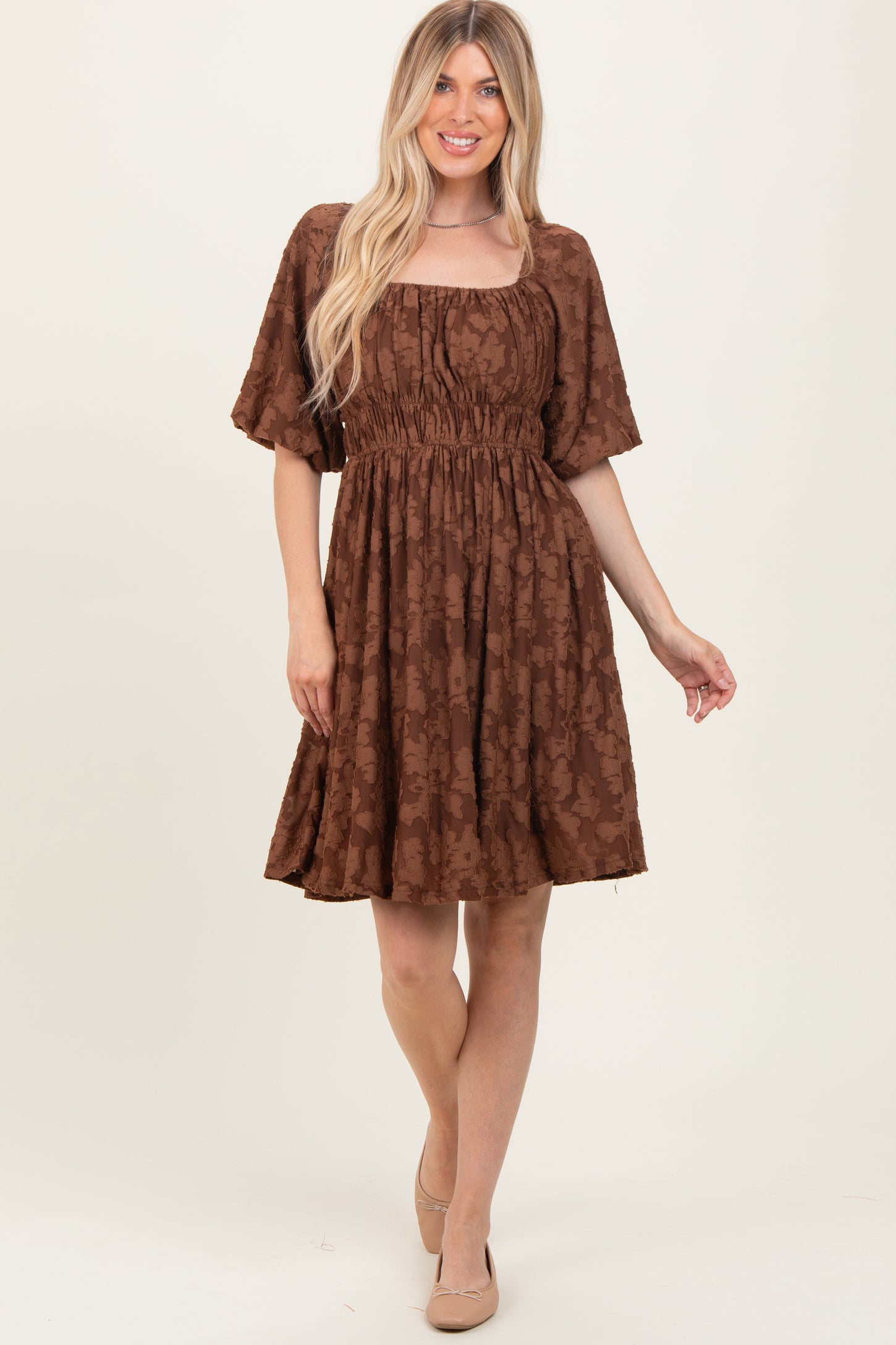woman wearing a brown floral print short dress with a square neckline and short sleeves