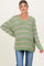 woman wearing a green and pink striped maternity sweater with a v-neck and relaxed fit, baby bump visible