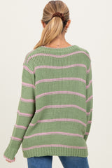 woman wearing a green and pink striped maternity sweater, seen from the back