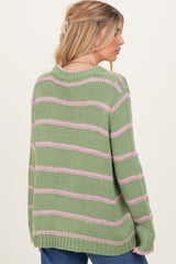 woman wearing a green and pink striped oversized sweater, view from the back