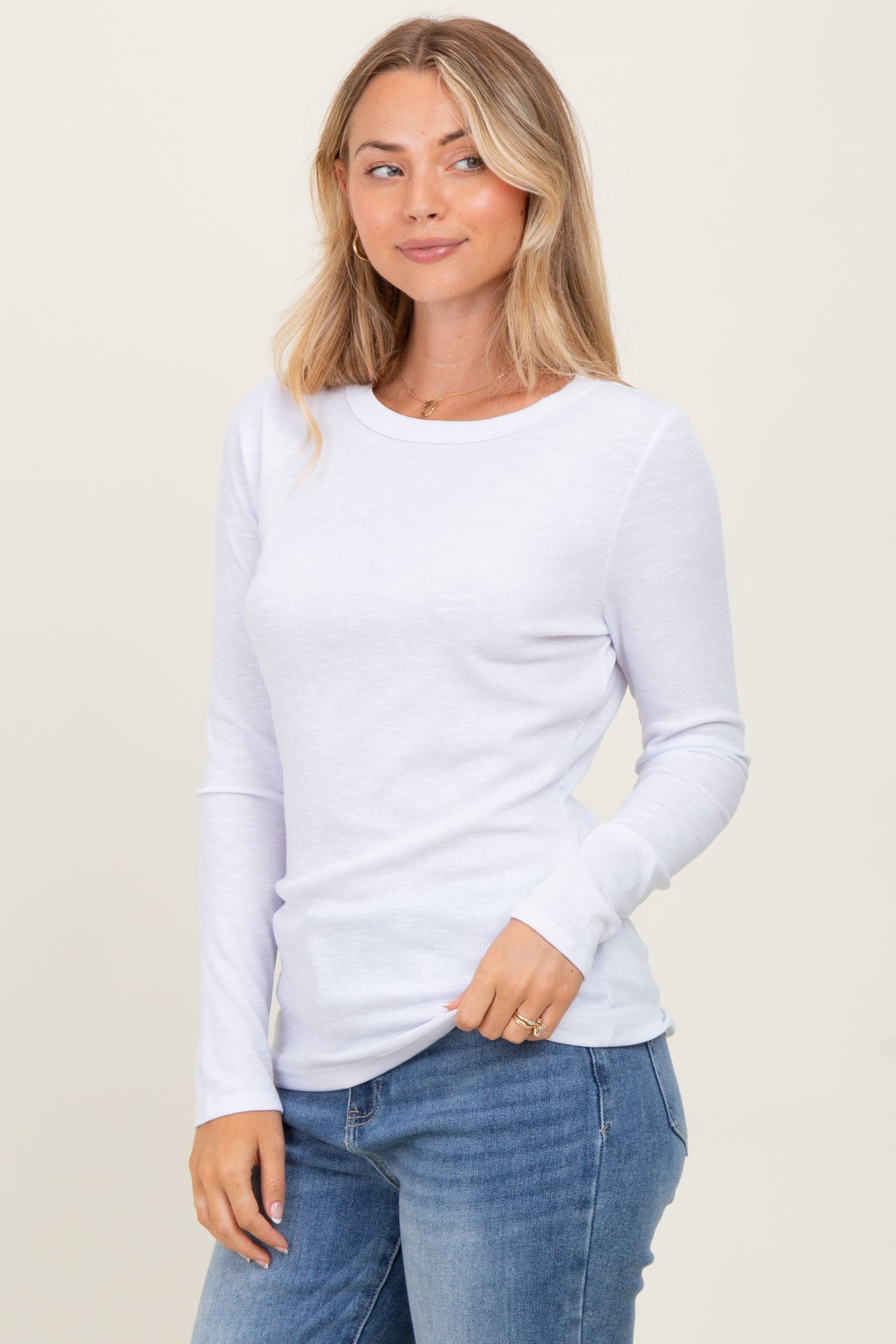 woman wearing a white long sleeve ribbed top paired with blue jeans