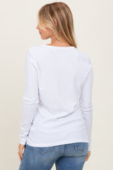 woman wearing a white long sleeve top, showing the back view, paired with light blue jeans