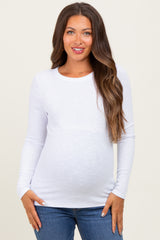 woman wearing a white long sleeve maternity top and showing her baby bump