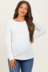 woman wearing a white long sleeve ribbed maternity top and showing her baby bump