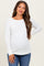 woman wearing a white long sleeve ribbed maternity top and showing her baby bump