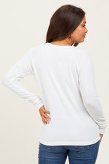 woman wearing a white ribbed maternity top, showing the back view with long sleeves and a relaxed fit