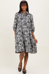 woman wearing a black and white floral print shirt dress with three-quarter sleeves and a relaxed fit