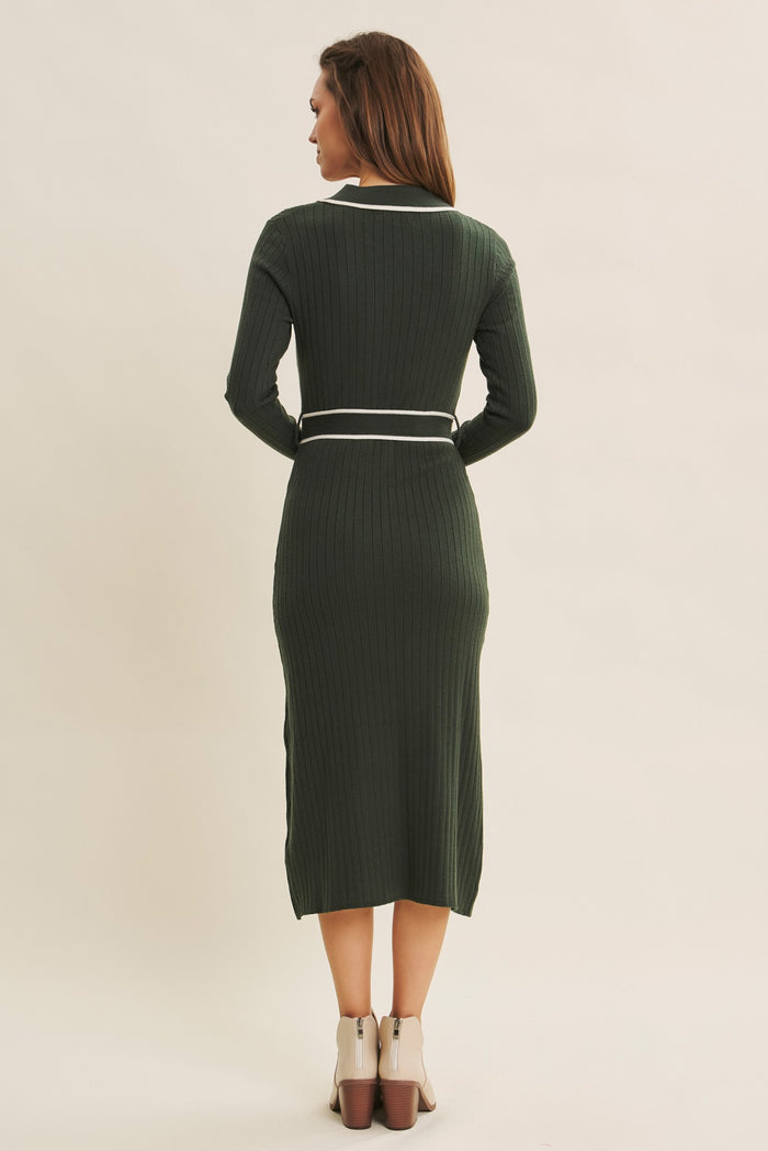 woman wearing a dark green ribbed midi dress with long sleeves and a white belt detail, shown from the back