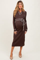 woman wearing a chocolate brown ribbed maternity dress with white trim and a tied waistband, highlighting her baby bump