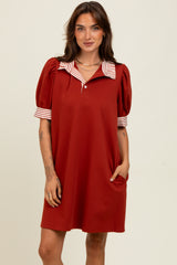 woman wearing a red short sleeve polo dress with striped collar and cuff details
