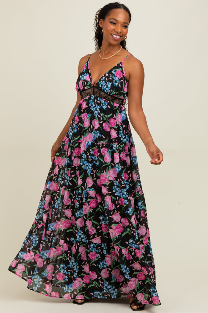 woman wearing a black maxi dress with pink and blue floral print and thin straps