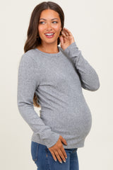 woman wearing a heather gray maternity top with ribbed details and a visible baby bump