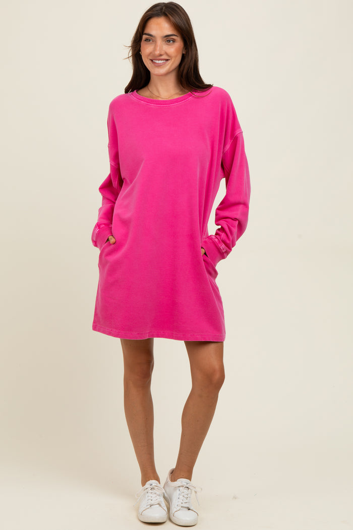 woman wearing a hot pink oversized sweatshirt dress with pockets and long sleeves, paired with white sneakers
