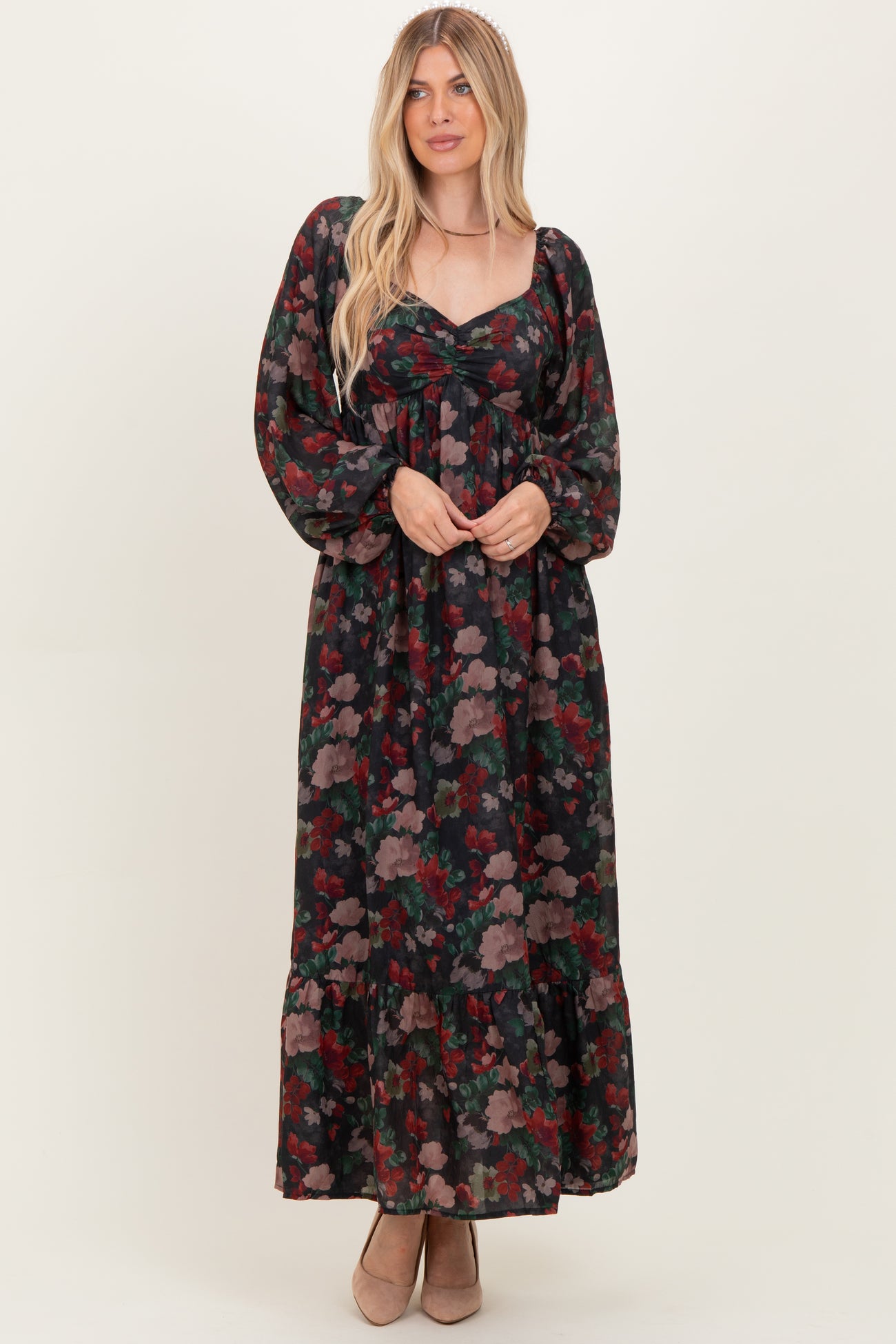 woman wearing a floral long sleeve maxi dress with a sweetheart neckline and ruffle hem