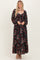 woman wearing a floral long sleeve maxi dress with a sweetheart neckline and ruffle hem