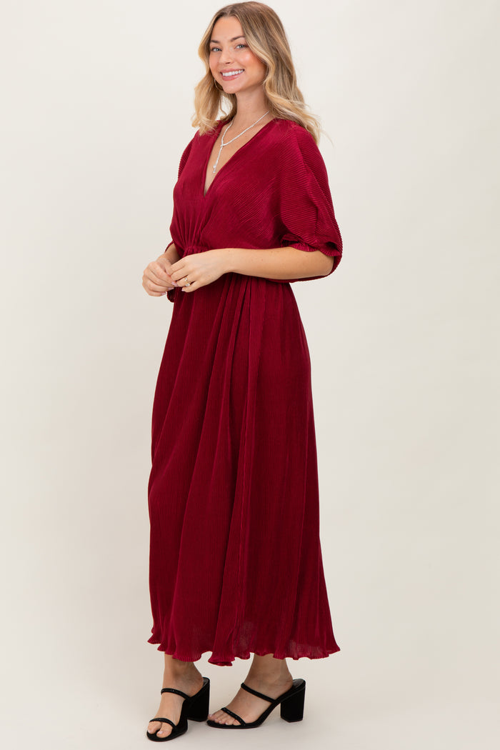 woman wearing a burgundy maxi dress with short sleeves and a v-neckline, styled with black heeled sandals